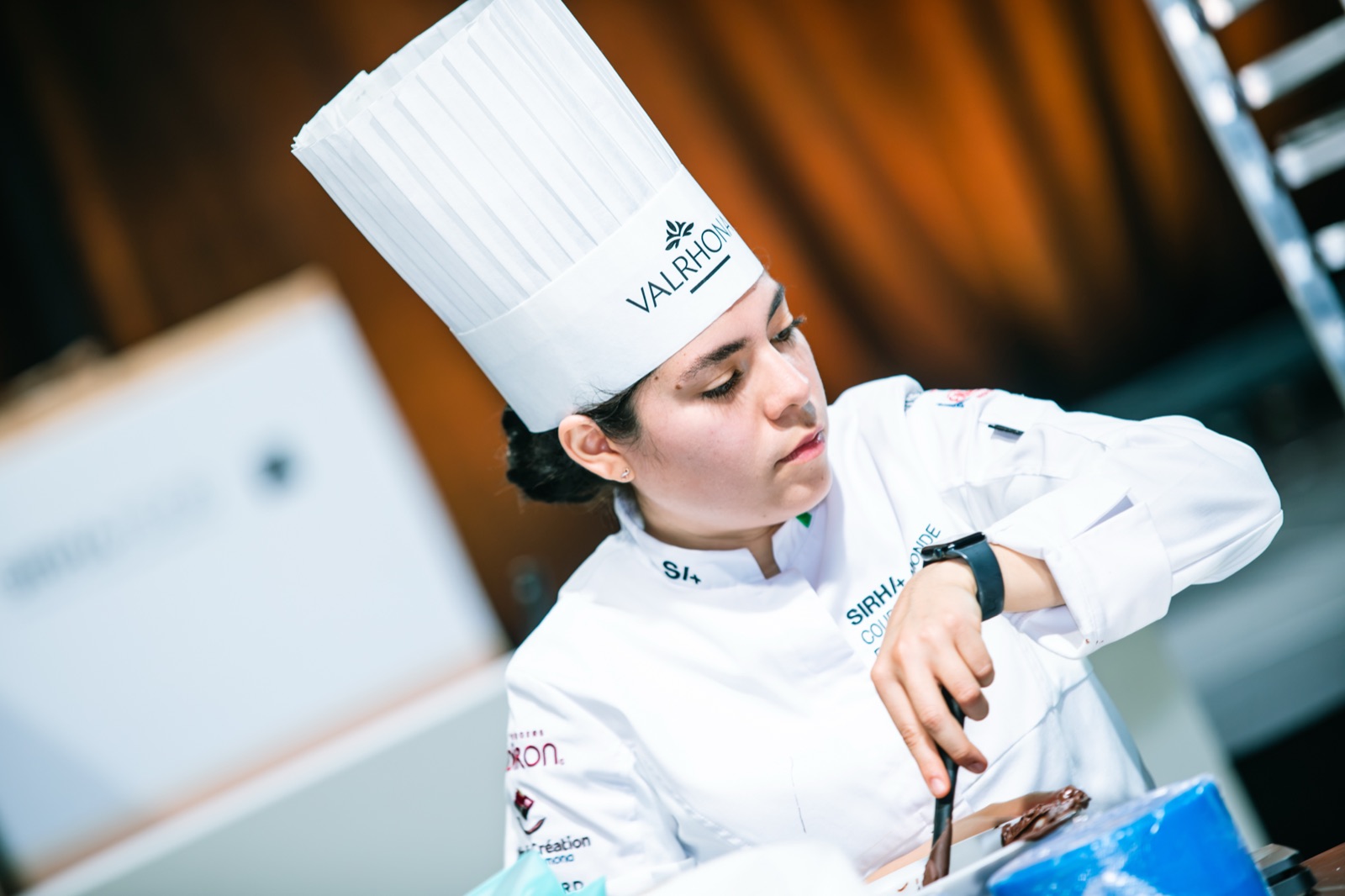 Roxana Flores concentrada en el templado de chocolate durante la competencia